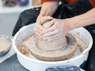 The potter kneads the clay before using it on the potter's wheel. Close-up of a man's hands. 