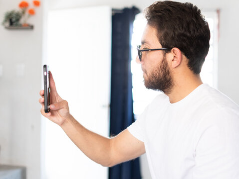 Joven apuesto tomando una fotograf&iacute;a con su tel&eacute;fono celular. Creador de contenido 