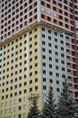 Obraz premium A very tall building is currently under construction, and it features a large number of windows, which will likely provide ample natural light when finished and occupied