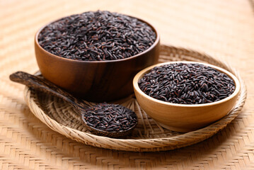 Organic rice berry or purple rice in wooden bowl with spoon, Thai rice