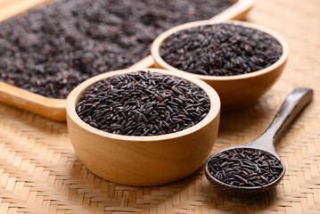 Organic rice berry or purple rice in wooden bowl with spoon, Thai rice