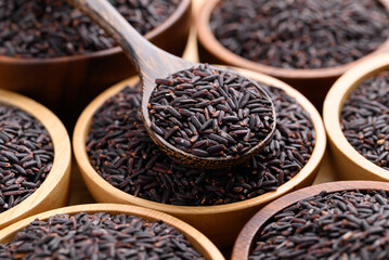 Organic rice berry or purple rice in wooden bowl with spoon, Thai rice