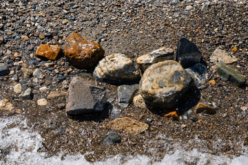 Wet stones on the lake shore beautiful color rocks close up view