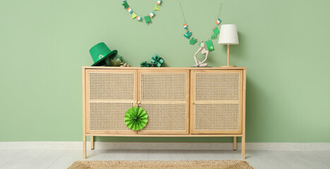 Interior of festive living room with wooden cabinet and decorations for St. Patrick's Day celebration