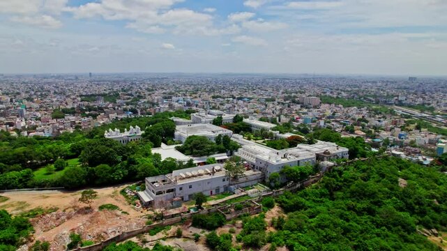 Taj Falaknuma Palace with hyderabad city view, sky and clouds at Engine Bowli, Falaknuma, Hyderabad, Telangana, india. day time, Semi orbit, drone shot, 4k