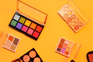 Beautiful palettes of eyeshadows on orange background