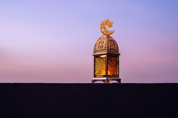 Golden lantern that have moon symbol on top with dusk sky background