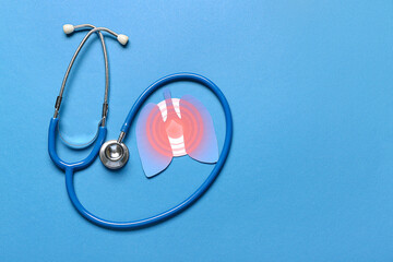 Paper lungs with stethoscope on blue background