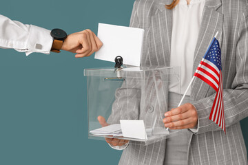 Hand putting voting paper into ballot box on blue background. Election concept