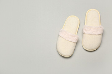 White soft slippers on grey background. Top view