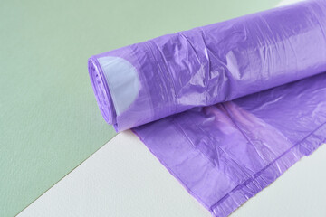 roll of purple plastic garbage bags on a white and green background.