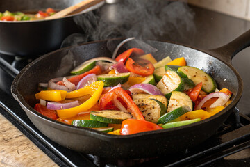 A cast iron skillet with sizzling vegetables