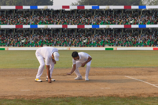 Cricket caption and Bowler inspecting the pitch before the start of a match