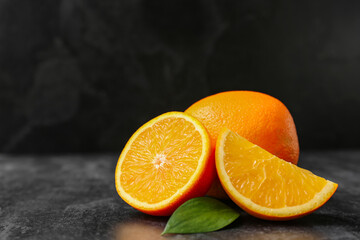 Fresh ripe oranges and leaf on black background