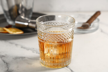 Glass of cold rum on table against blurred background. Closeup