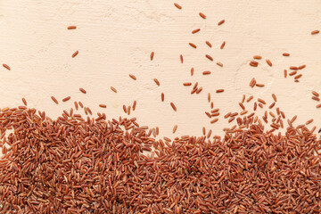Raw brown rice on beige background