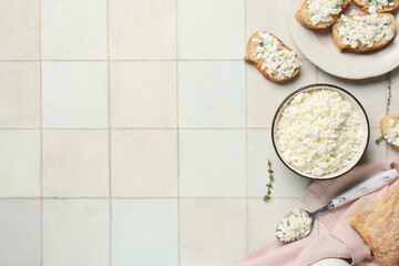 Plate of bread slices with fresh cottage cheese and thyme on white tile background