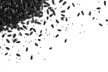 Black sunflower seeds scattered on white background. (1)