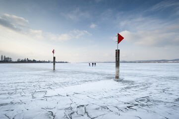 Navigation mark on a frozen Lake Constance with skaters, island auf Reichenau, Konstanz district,...