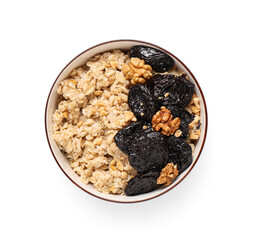 Bowl of tasty oatmeal with prunes and walnuts on white background