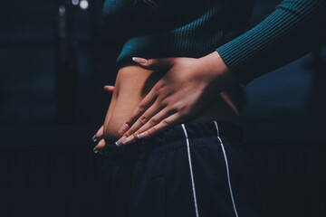 woman's hand holding excessive belly fat, overweight concept