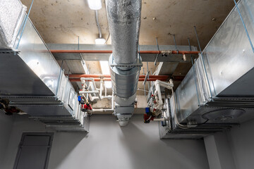 Modern ventilation system with exposed ducts and pipes in a commercial building
