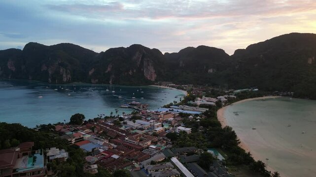A mesmerising sunset flight over Koh Phi Phi beach in Thailand, with striking moody colours and shimmering azure waters.
