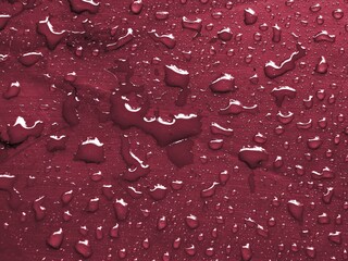 Water drops on wine color metallic surface