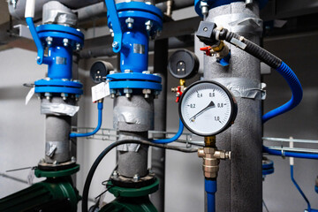 Industrial plumbing setup with pressure gauge and valves in a commercial space