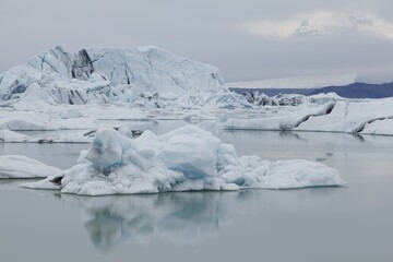 Icebergs being reflected on the calm Joekulsarlon glacial lake, Iceland, Europe