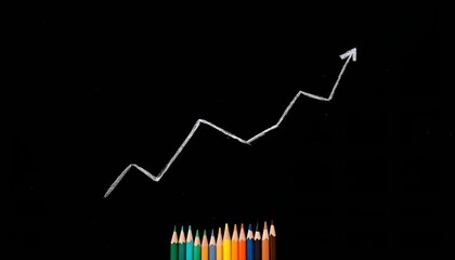 Bisiness,conceot,economic,finance,A black chalkboard with a white zigzag line drawn on it, representing a graph or trend. At the bottom, there are several colored pencils arranged in a row