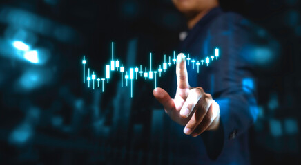 investment and finance concept, businessman holding virtual trading graph and blurred light on...