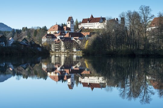 The former Franciscan Monastery of St. Mang, reflection of the castle at top in the Lech river, Fuessen, Ostallgaeu region, Allgaeu, Bavaria, Germany, Europe