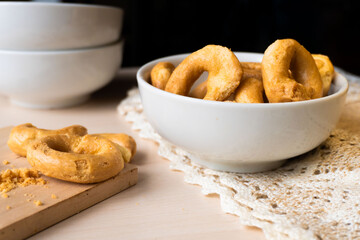 Artisanal homemade typical apulian taralli bowl wooden cutting board, crumbles, baked snack aperitif south italian culture. Flat lay 
