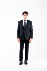 A man in a black suit and tie stands in front of a white background