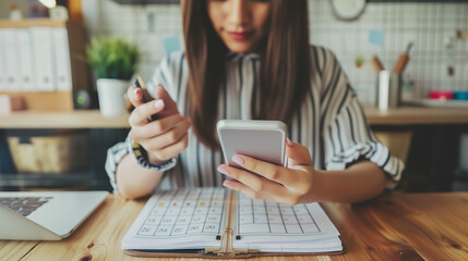 Event planner timetable agenda plan on organize schedule event. Business woman using mobile phone and taking note on calendar desk on office table 