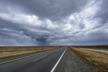 Road with thunderstorm mood by the pampa of Patagonia, near Rio Gallegos, Argentina, South America