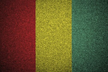 The Guinean flag painted on a cork board