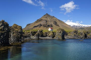 Lonely house on the basalt coast near the harbour, behind the mountain Stapafell and the glacier...