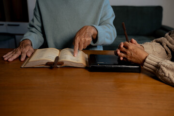 Men and women praying to God with the Bible.