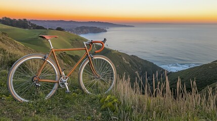 Fototapeta premium A road bike parked on a scenic cliffside overlooking the ocean at sunset.