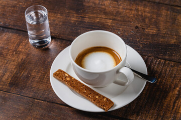 cafe macchiato coffee in white porcelain cup on wooden table