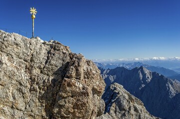 Fototapeta premium Gilded summit cross, Zugspitze, view towards Tyrol behind, Garmisch-Partenkirchen, Wetterstein, Eastern Alps, Upper Bavaria, Bavaria, Germany, Europe