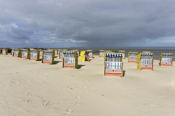 Dark clouds over the North Sea, beach chairs on sandy beach, Cuxhaven, Lower Saxony, Germany, Europe