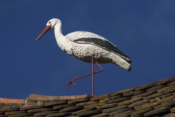 White stork figure on a roof, blue sky, Ribeauvillé, Alsace, France, Europe