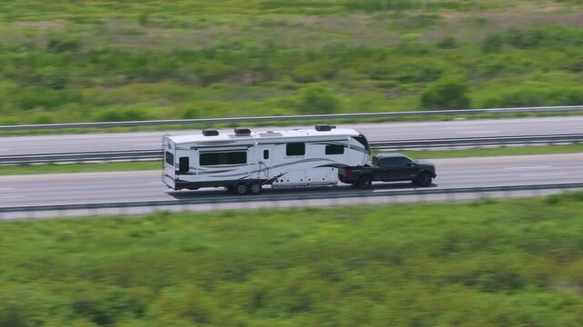 Truck towing RV camper trailer driving at high speed on American freeway in Florida. USA travel transportation infrastructure