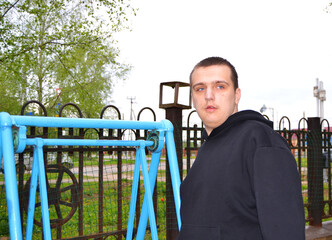 Autistic guy in a black sweater on a walk in the park