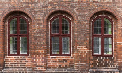 Three windows on an old brick house, Lüneburg, Lower Saxony, Germany, Europe