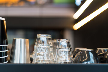 Clean shot glass and ceramic coffee cups lie upside down on a coffee machine in a cafe. Close up. Selective focus.