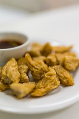 Fried fish balls in white plate served with simmered sugar dipping sauce with chili